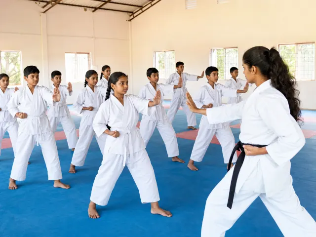 Indian school students practising martial arts with a female instructor