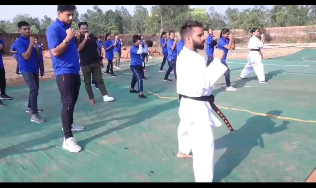 Students watching a martial arts demonstration during an outdoor program.
