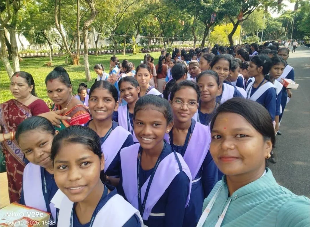 Smiling students in uniform gathered for a group selfie outdoors.