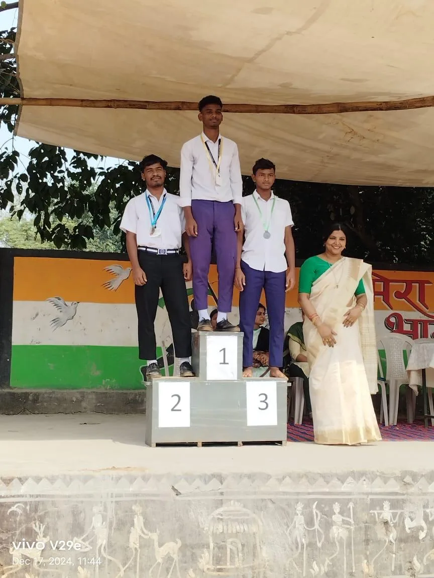 A student standing on a winners podium during an awards ceremony.